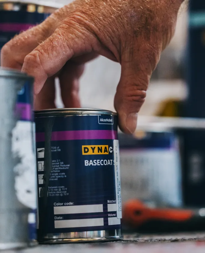 Picture of a hand holding paint small tin