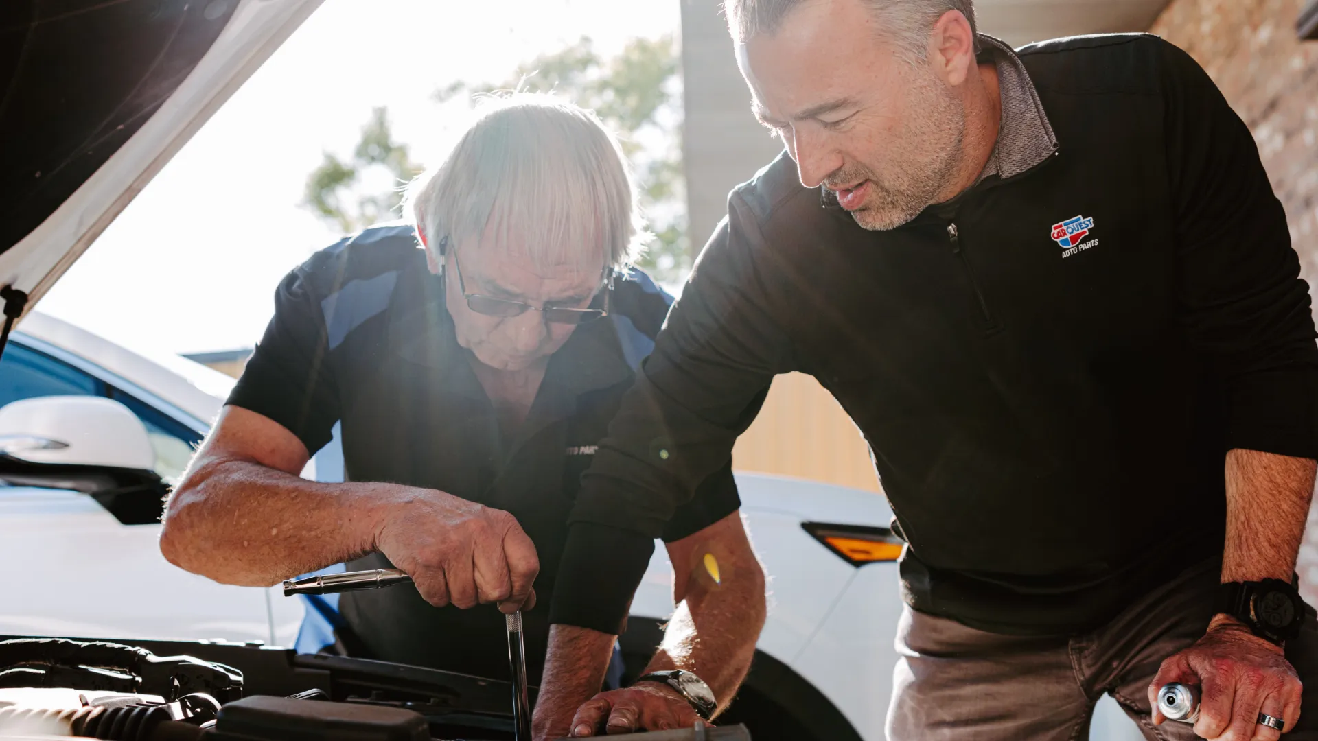 Picture of two people fixing a car